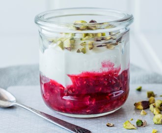 Yoghurt og rørte bringebær med pistasjnøtter
