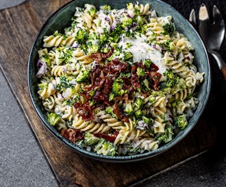 Kremet pastasalat med rå brokkoli, rødløk, eple og sprøstekt bacon