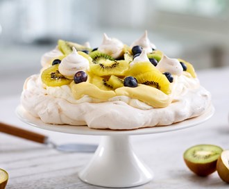 Pavlova med gul og grønn kiwi, blåbær og appelsin