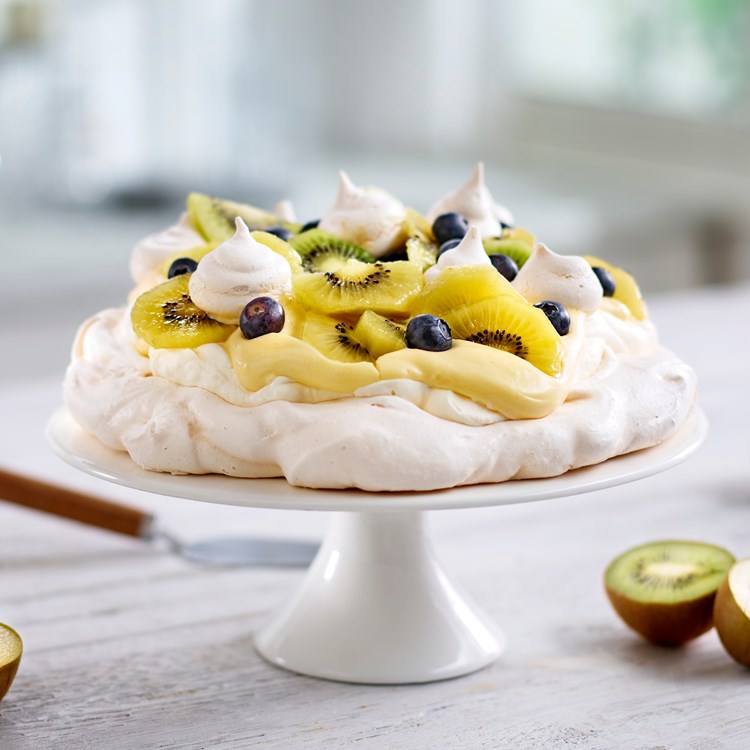 Pavlova med gul og grønn kiwi, blåbær og appelsin